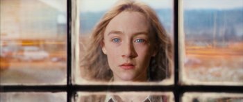 Movie still from “The Lovely Bones” (2009), directed by Peter Jackson – A young woman looking at the camera through a window; Close Up shot, Low angle