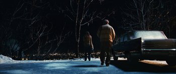 Movie still from “The Lovely Bones” (2009), directed by Peter Jackson – A man and a woman are walking in the snow; Wide shot, High angle