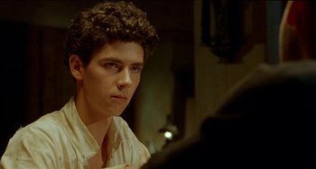 Movie still from “The Lover” (1992), directed by Jean-Jacques Annaud – A man sitting in front of a piano in a room; Close Up shot, Over the shoulder angle