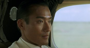 Movie still from “The Lover” (1992), directed by Jean-Jacques Annaud – A person sitting in a vehicle; Close Up shot, Over the shoulder angle