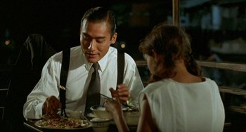 Movie still from “The Lover” (1992), directed by Jean-Jacques Annaud – A man and a woman are sitting at a dinner table; Close Up shot, Over the shoulder angle