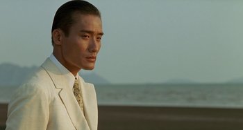 Movie still from “The Lover” (1992), directed by Jean-Jacques Annaud – A person wearing a suit and tie; Close Up shot, Over the shoulder angle