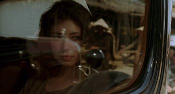 Movie still from “The Lover” (1992), directed by Jean-Jacques Annaud – A woman sitting in a car looking out the window; Close Up shot, Over the shoulder angle
