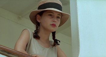 Movie still from “The Lover” (1992), directed by Jean-Jacques Annaud – A young girl wearing a hat with pigtails; Close Up shot, Low angle