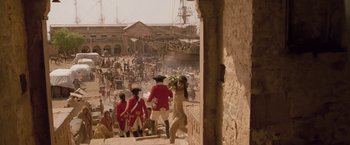 Movie still from “The Lovers” (2015), directed by Roland Joffé – A group of men in red and white uniforms walking down a street; Extreme Wide shot, High angle