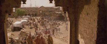 Movie still from “The Lovers” (2015), directed by Roland Joffé – A group of people standing around a market; Extreme Wide shot, High angle