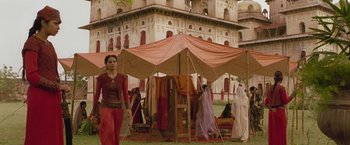 Movie still from “The Lovers” (2015), directed by Roland Joffé – A group of people standing under a tent; Wide shot, Low angle