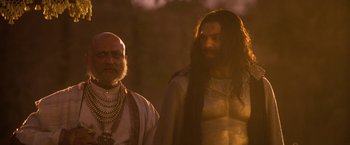 Movie still from “The Lovers” (2015), directed by Roland Joffé – Two men standing next to each other in the dark; Medium shot, Over the shoulder angle