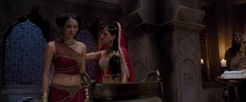 Movie still from “The Lovers” (2015), directed by Roland Joffé – Two women dressed up in indian garb in front of a pot; Medium shot, Over the shoulder angle