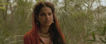Movie still from “The Lovers” (2015), directed by Roland Joffé – A woman in a red dress and a gold necklace; Close Up shot, Over the shoulder angle