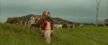 Movie still from “The Lovers” (2015), directed by Roland Joffé – A group of people riding horses in a grassy field; Wide shot, Low angle