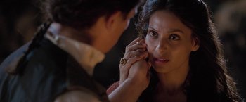 Movie still from “The Lovers” (2015), directed by Roland Joffé – A woman looking at the camera while a man adjusts her earring; Close Up shot, Over the shoulder angle