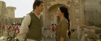 Movie still from “The Lovers” (2015), directed by Roland Joffé – A man and a woman standing next to each other in front of an archway; Medium shot, Low angle