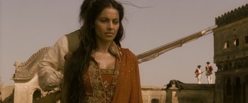 Movie still from “The Lovers” (2015), directed by Roland Joffé – A woman with long black hair wearing an orange dress; Medium shot, Over the shoulder angle