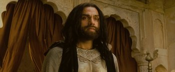 Movie still from “The Lovers” (2015), directed by Roland Joffé – A man with long black hair and a long beard; Close Up shot, Low angle