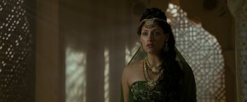 Movie still from “The Lovers” (2015), directed by Roland Joffé – A woman in a green dress and a gold necklace; Close Up shot, Over the shoulder angle