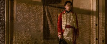 Movie still from “The Lovers” (2015), directed by Roland Joffé – A man in a red and white uniform holding a sword; Medium shot, Low angle