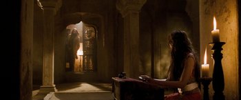 Movie still from “The Lovers” (2015), directed by Roland Joffé – A woman sitting on a couch in front of an open door; Wide shot, Low angle