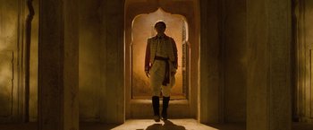 Movie still from “The Lovers” (2015), directed by Roland Joffé – A man standing in a doorway wearing a red jacket; Wide shot, Low angle