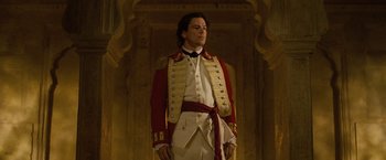 Movie still from “The Lovers” (2015), directed by Roland Joffé – A man in a white and red uniform standing in a room; Medium shot, Low angle
