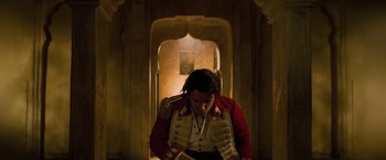 Movie still from “The Lovers” (2015), directed by Roland Joffé – A man in a red and white jacket looking down; Medium shot, High angle