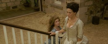 Movie still from “The Lovers” (2015), directed by Roland Joffé – A woman and a young girl standing next to a railing; Medium shot, High angle