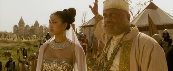 Movie still from “The Lovers” (2015), directed by Roland Joffé – A man and a woman standing next to each other in front of tents; Close Up shot, Over the shoulder angle