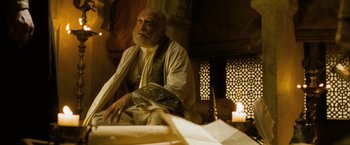 Movie still from “The Lovers” (2015), directed by Roland Joffé – An older man sitting in a room with a candle; Medium shot, Low angle