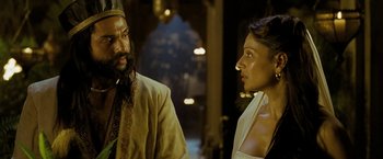 Movie still from “The Lovers” (2015), directed by Roland Joffé – A man and a woman standing next to each other in front of an archway; Close Up shot, Over the shoulder angle