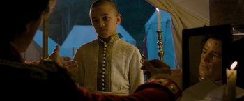 Movie still from “The Lovers” (2015), directed by Roland Joffé – A young man in a white shirt and a white and gold jacket; Medium shot, Over the shoulder angle