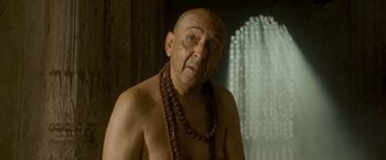 Movie still from “The Lovers” (2015), directed by Roland Joffé – An older man with a beard and a necklace; Close Up shot, Low angle