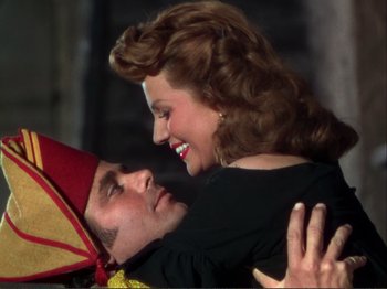 Movie still from “The Loves of Carmen” (1948), directed by Charles Vidor – A man and a woman embracing each other in front of a building; Medium shot, Overhead angle