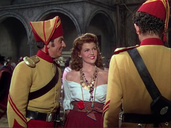 Movie still from “The Loves of Carmen” (1948), directed by Charles Vidor – A man and a woman standing next to each other; Medium shot, Over the shoulder angle