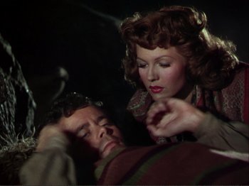 Movie still from “The Loves of Carmen” (1948), directed by Charles Vidor – A man and a woman are laying on a bed; Medium shot, Overhead angle