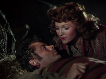 Movie still from “The Loves of Carmen” (1948), directed by Charles Vidor – A man and a woman laying on the ground; Medium shot, Over the shoulder angle