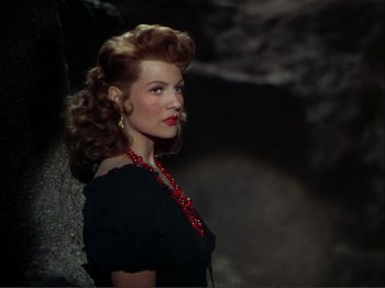 Movie still from “The Loves of Carmen” (1948), directed by Charles Vidor – A woman in a black dress with a red necklace; Close Up shot, High angle