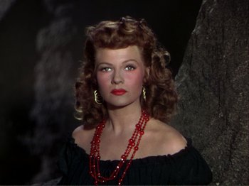 Movie still from “The Loves of Carmen” (1948), directed by Charles Vidor – A woman with red lipstick wearing a black dress; Close Up shot, High angle