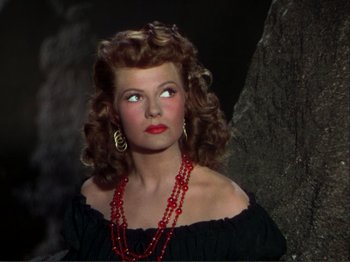 Movie still from “The Loves of Carmen” (1948), directed by Charles Vidor – A woman wearing a black dress and a red necklace; Close Up shot, High angle