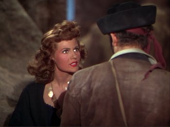 Movie still from “The Loves of Carmen” (1948), directed by Charles Vidor – A beautiful woman with red lipstick standing next to a man; Medium shot, Over the shoulder angle