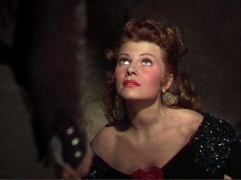 Movie still from “The Loves of Carmen” (1948), directed by Charles Vidor – A woman in a black dress holding a guitar; Close Up shot, Overhead angle
