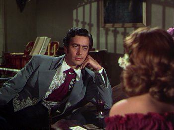 Movie still from “The Loves of Carmen” (1948), directed by Charles Vidor – A man and a woman sitting at a table talking to each other; Medium shot, Over the shoulder angle