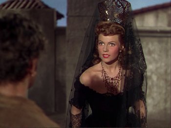 Movie still from “The Loves of Carmen” (1948), directed by Charles Vidor – A woman in a black dress and a black veil; Close Up shot, Over the shoulder angle