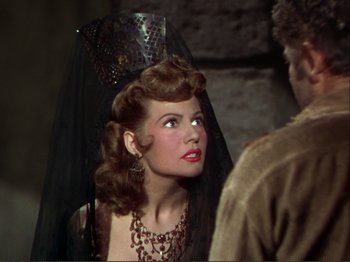 Movie still from “The Loves of Carmen” (1948), directed by Charles Vidor – A woman with a veil on her head; Close Up shot, Over the shoulder angle
