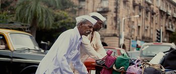 Movie still from “The Lunchbox” (2013), directed by Ritesh Batra – A couple of men riding bikes down a street; Medium shot, Low angle