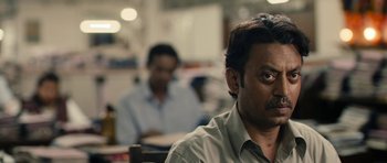 Movie still from “The Lunchbox” (2013), directed by Ritesh Batra – A man sitting in front of another man in a room; Close Up shot, Over the shoulder angle