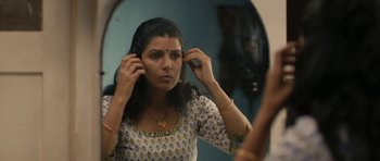Movie still from “The Lunchbox” (2013), directed by Ritesh Batra – A woman looking in a mirror while putting on her earrings; Close Up shot, Low angle