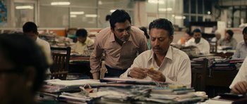 Movie still from “The Lunchbox” (2013), directed by Ritesh Batra – Two men sitting at a table in front of papers; Medium shot, High angle