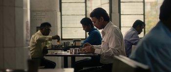 Movie still from “The Lunchbox” (2013), directed by Ritesh Batra – A man sitting at a table in front of two other men; Medium shot, Low angle