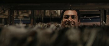 Movie still from “The Lunchbox” (2013), directed by Ritesh Batra – A man smiling for the camera while looking at the camera; Close Up shot, Low angle