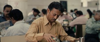 Movie still from “The Lunchbox” (2013), directed by Ritesh Batra – A man in a brown shirt is pouring something into a cup; Close Up shot, High angle